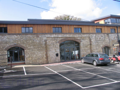 The mill from the car park: granite walls below a cedar-clad upper floor